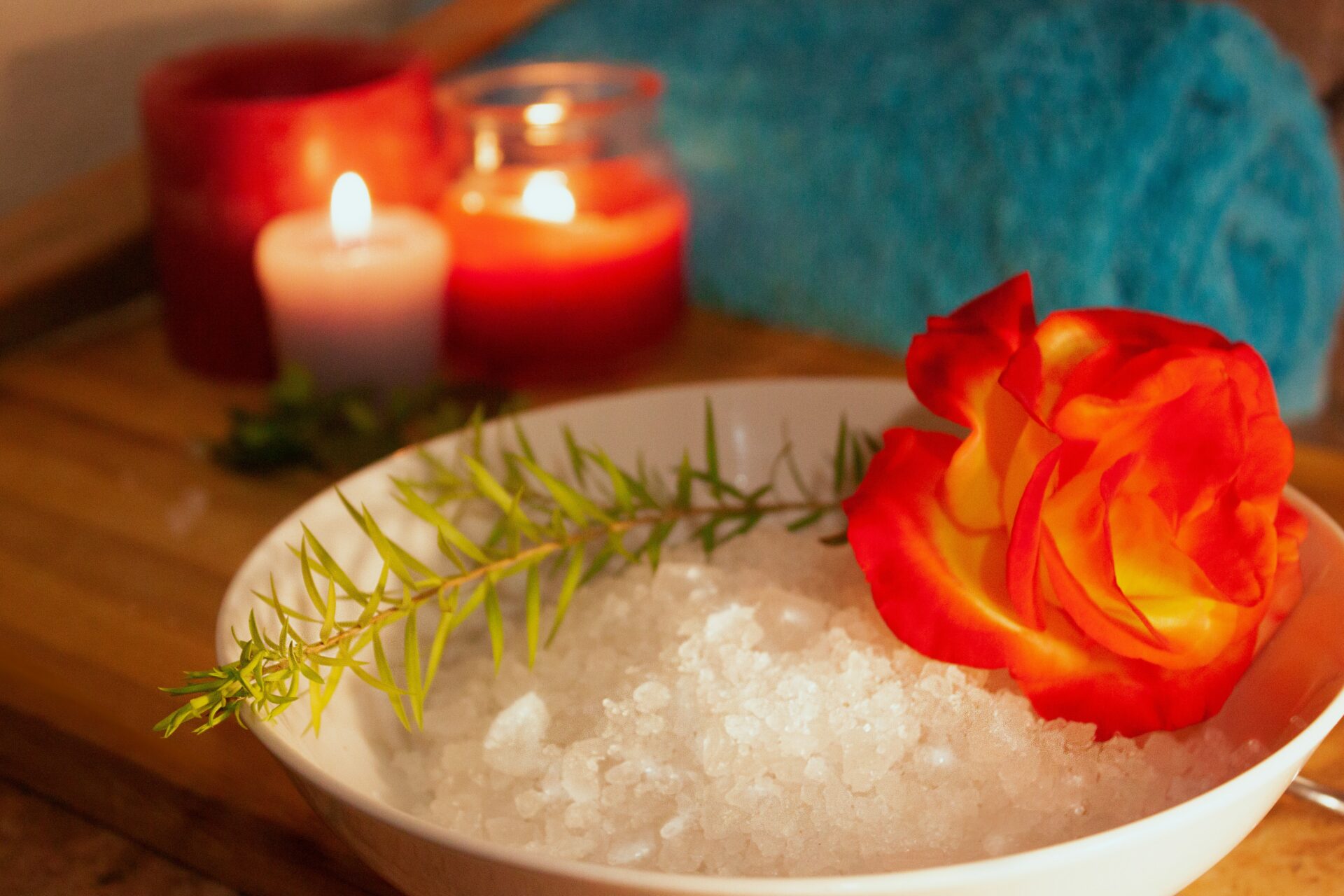 Entspannung mit Salzschale, einer Rose und Kräutern mit zwei Kerzen.
