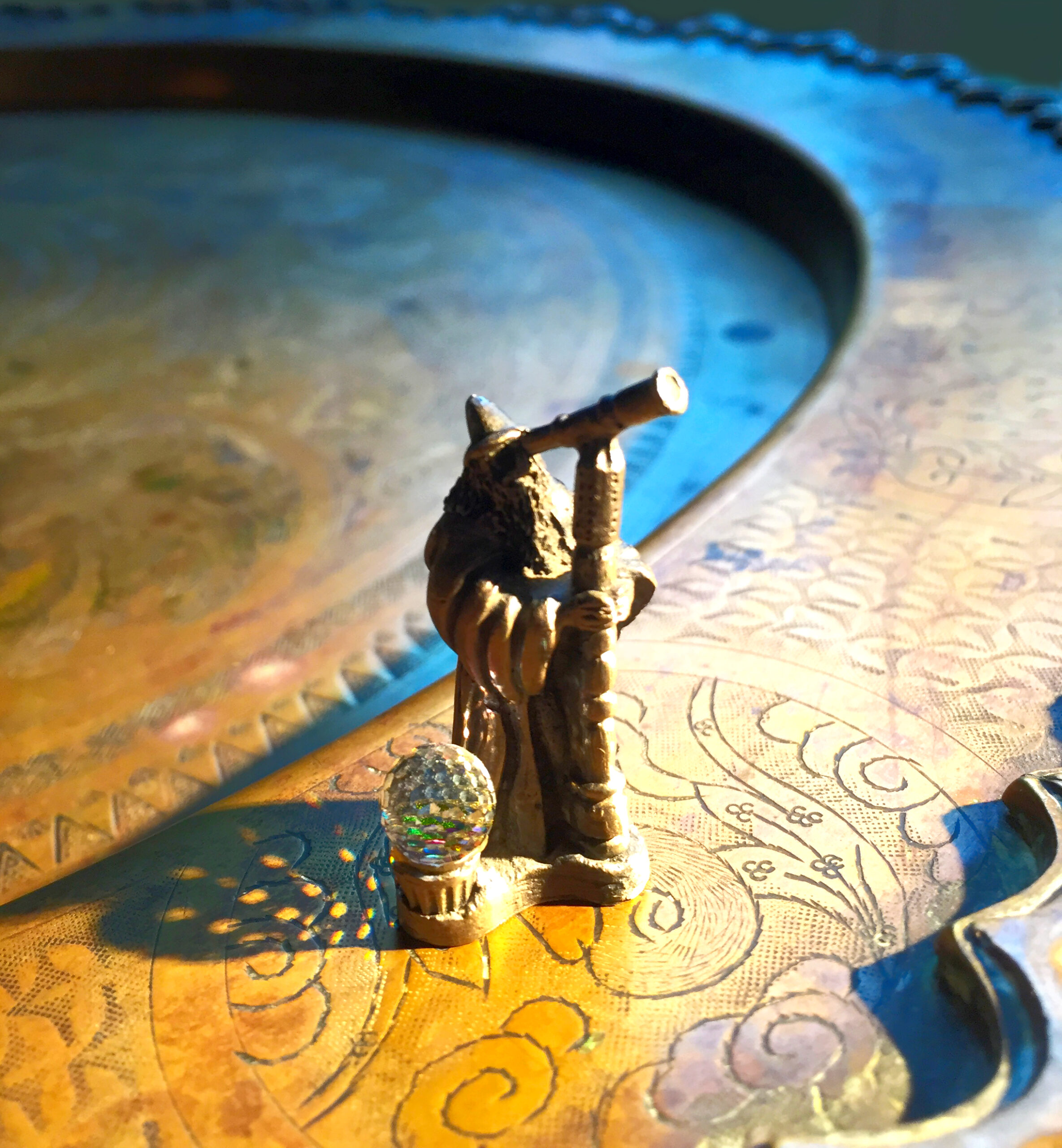 Kleine Skulptur von einem Magier mit Fernglas stehend auf einem Tisch