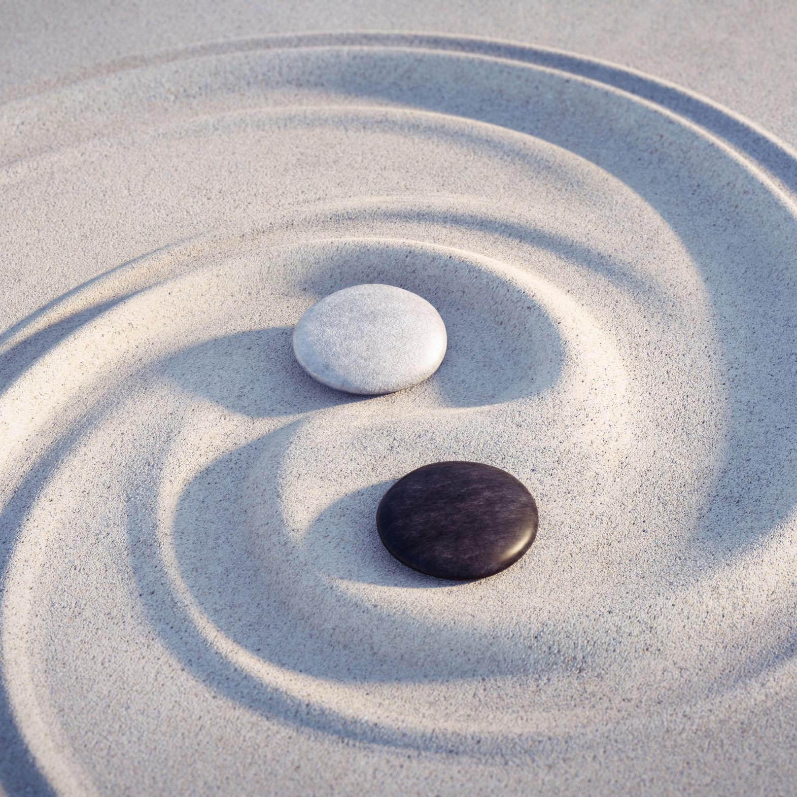 Zwei Steine im Sand mit YinYang-Zeichen